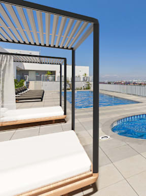 A pool on a balcony with a chair and a table.