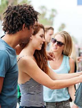people looking at a pair of jeans at an outdoor market