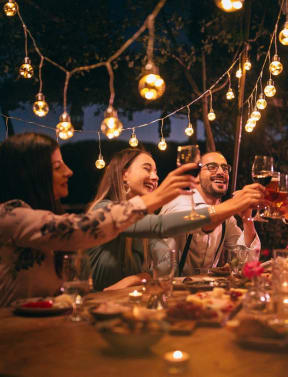 a group of people sitting around a table drinking wine