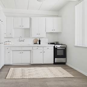 A modern kitchen with white cabinets and a stainless steel refrigerator.