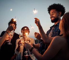 A group of people holding sparklers at a party.