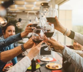 group of people toasting wine glasses in a restaurant