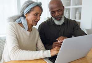 An Older Couple is Looking at a Laptop at Peregrine Apartments, Minneapolis, Minnesota