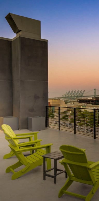 a patio with green chairs and yellow umbrellas at dusk