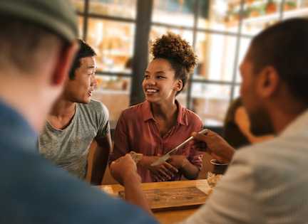 A group of people are sitting around a table, engaged in conversation.
