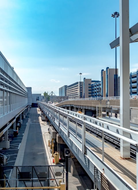 a view of a train station with a train on the tracks and buildings in the background
