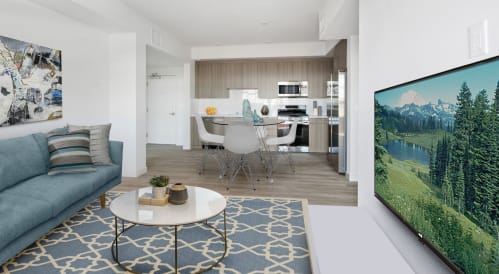 a living room with a couch a table and chairs and a tv on the wall