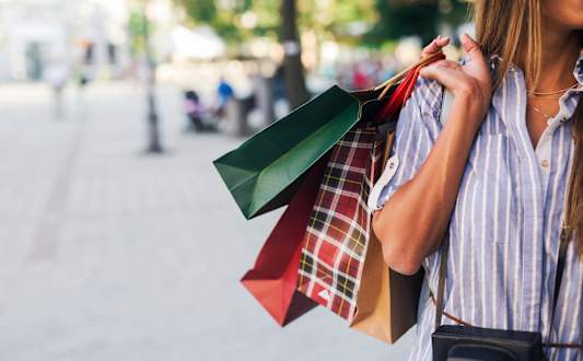 A woman is holding shopping bags in her hands.