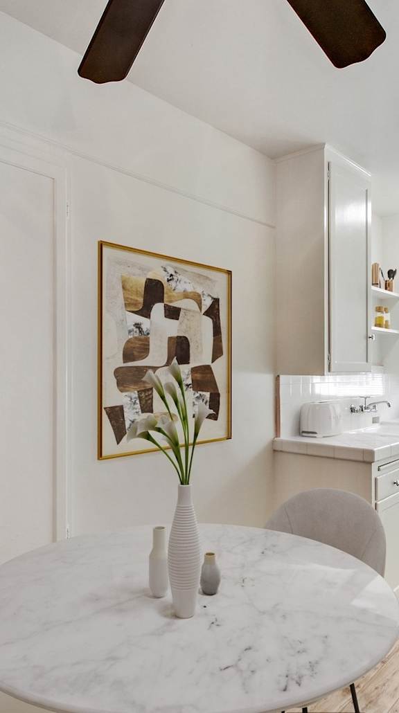 A white marble table with a vase of flowers on it.