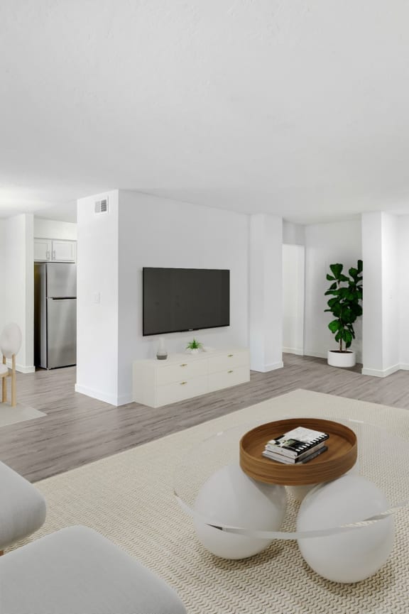 a living room with white furniture and a television