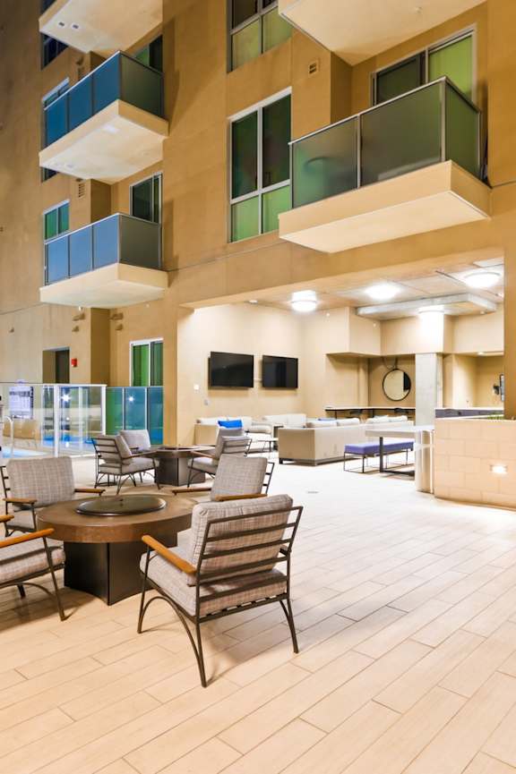 A patio with a table and chairs is surrounded by apartment buildings.