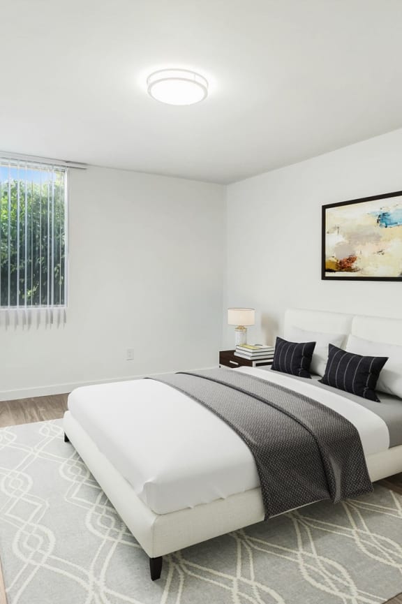 a white bedroom with a bed and a sliding glass door