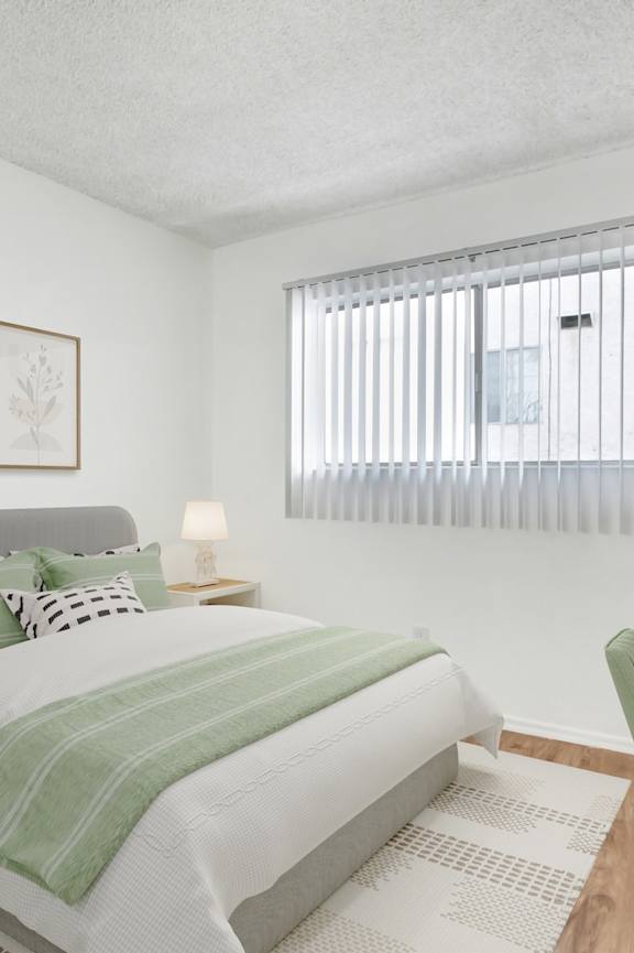 A bedroom with a bed, nightstand, and chair.