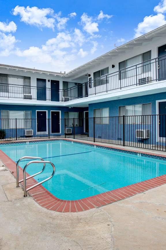 a swimming pool with a blue and white building in the background