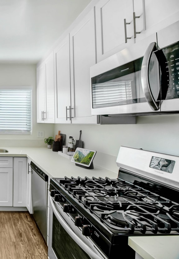a kitchen with white cabinets and a sink and a microwave