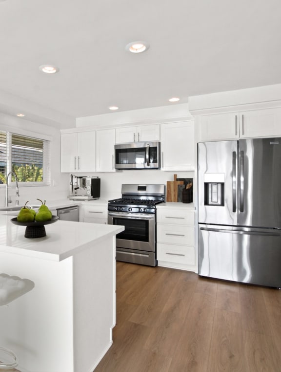 a kitchen with white cabinets and a blue rug