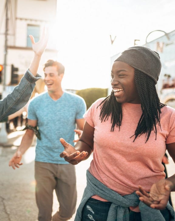 group of young people laughing and dancing in the street