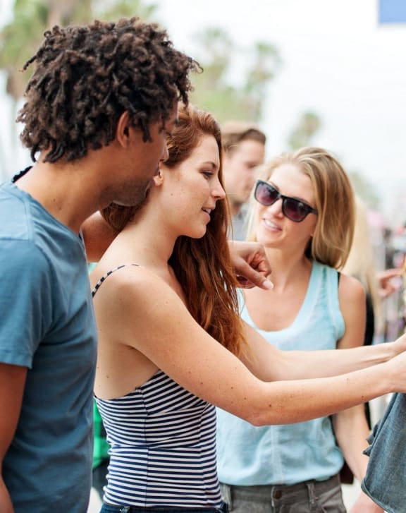 people looking at a pair of jeans at an outdoor market