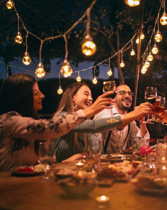 a group of people sitting around a table drinking wine