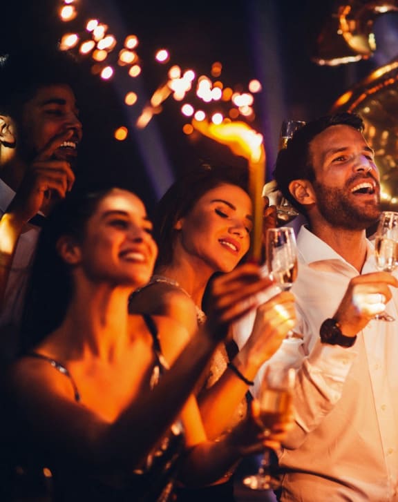 a group of people celebrating at a party with sparklers