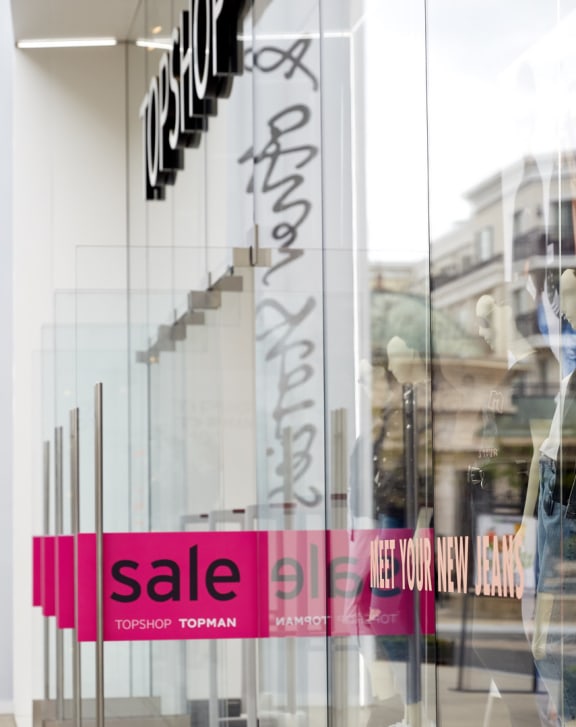 a store window with a sale sign in the window