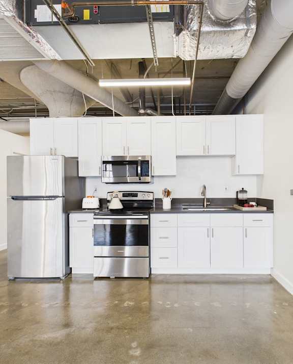 A modern kitchen with white cabinets and stainless steel appliances.