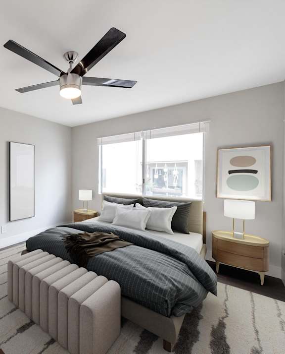 A modern bedroom with a large bed and a ceiling fan.