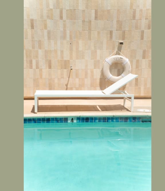 a swimming pool with a chair and aotation device in a hotel pool