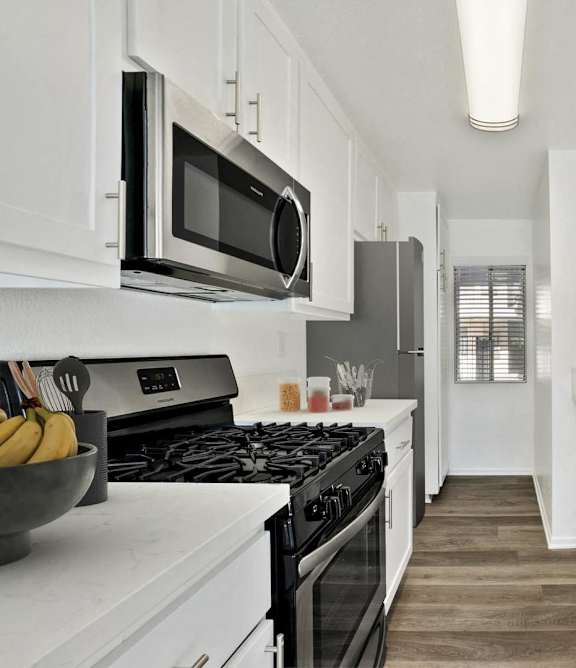 a kitchen with a sink and a stove and a microwave