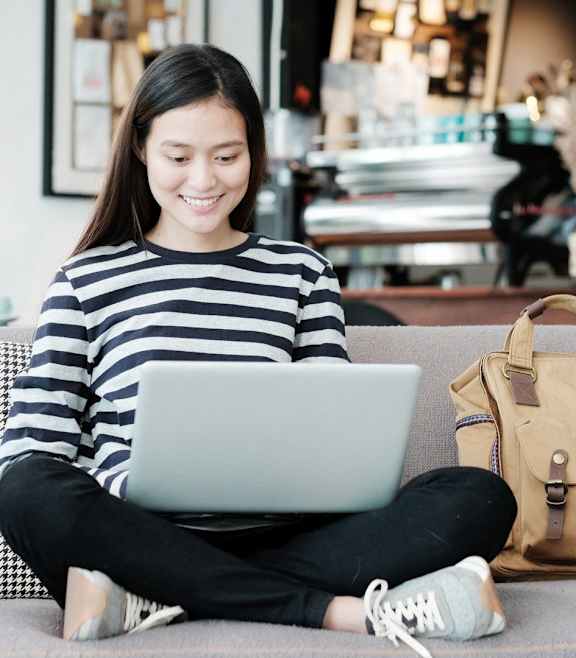 a woman sitting on a couch using a laptop computer at Skylar At Sunset, California