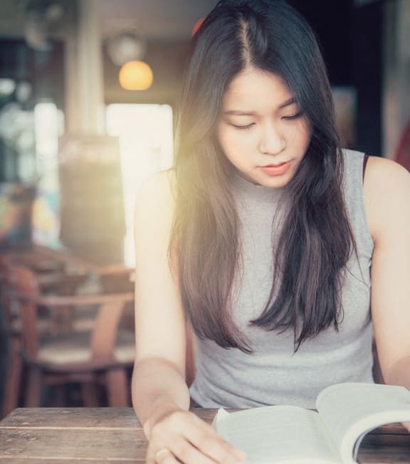a woman reading a book on a table