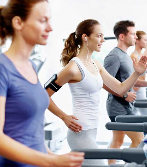 A group of people are exercising on treadmills in a gym at Meridian Apartments, California