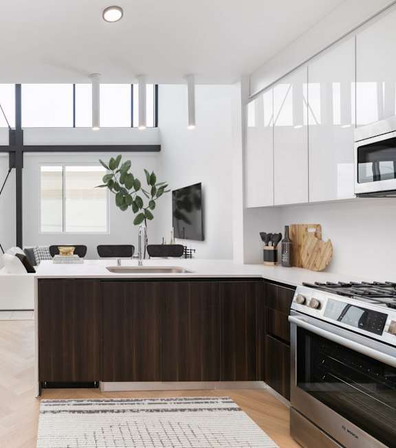 a kitchen and living room with a staircase in a house