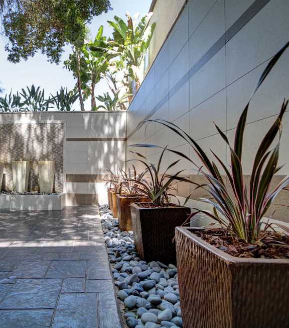 A modern courtyard with a water feature and potted plants.