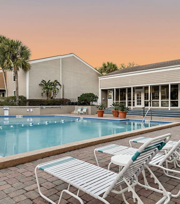 a large swimming pool with chairs and chairs around it
