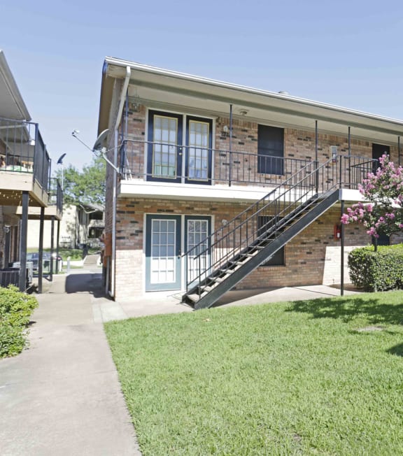 an exterior view of a brick apartment building at Archer Village Apartments, TX, 75092