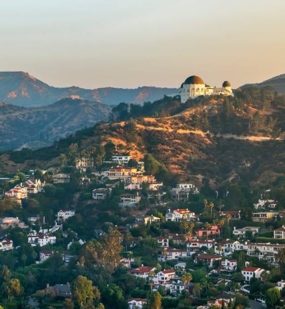 a city on a hill with mountains in the background