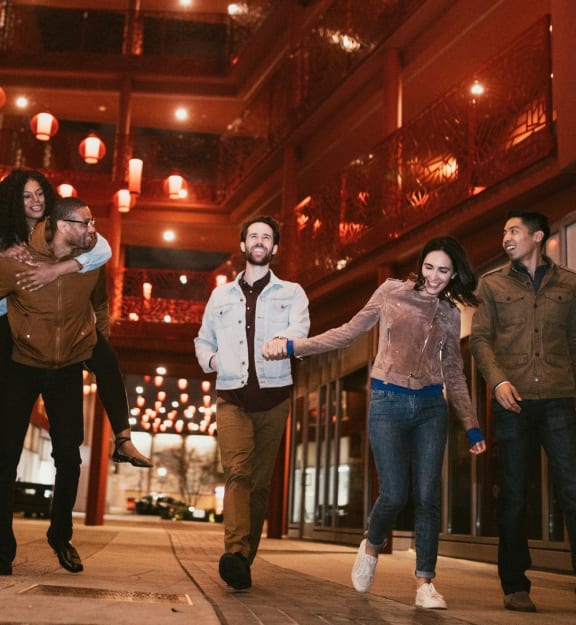 a group of people walking down a city street at night