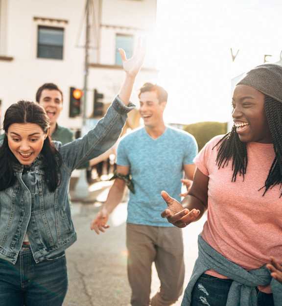 group of young people laughing and dancing in the street