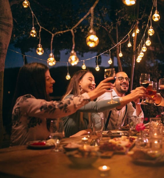 a group of people sitting around a table drinking wine