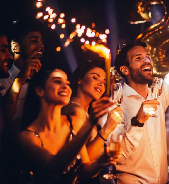 a group of people celebrating at a party with sparklers