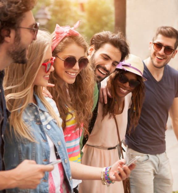 a group of young people looking at a cell phone
