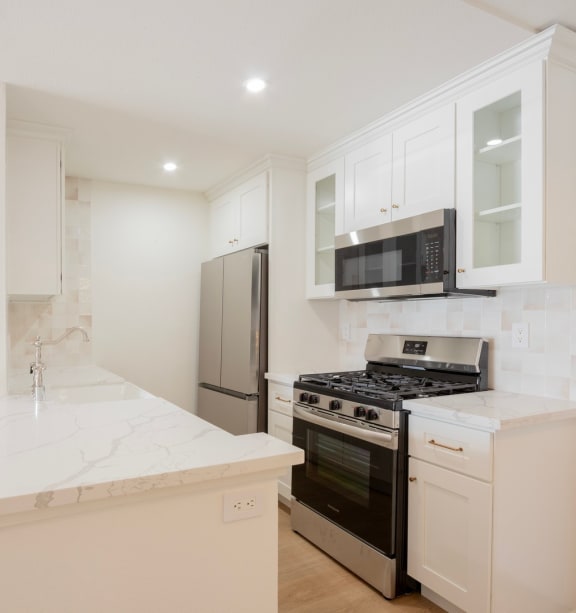 a kitchen with white cabinets and a stove and a refrigerator