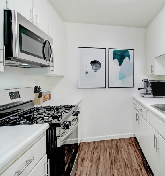 a kitchen with white cabinets and a sink and a microwave