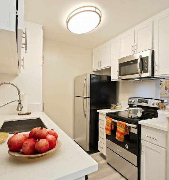the kitchen of a home with white cabinets and stainless steel appliances