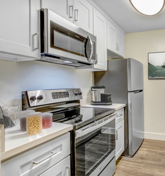 a kitchen with white cabinets and stainless steel appliances