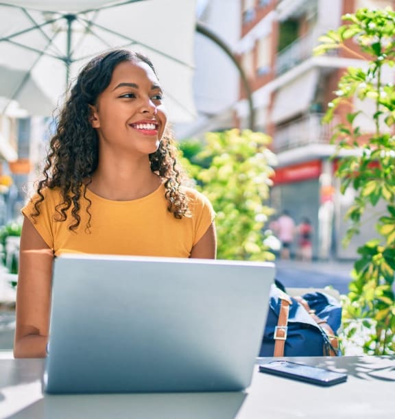 a woman sitting at a table with her laptop computer