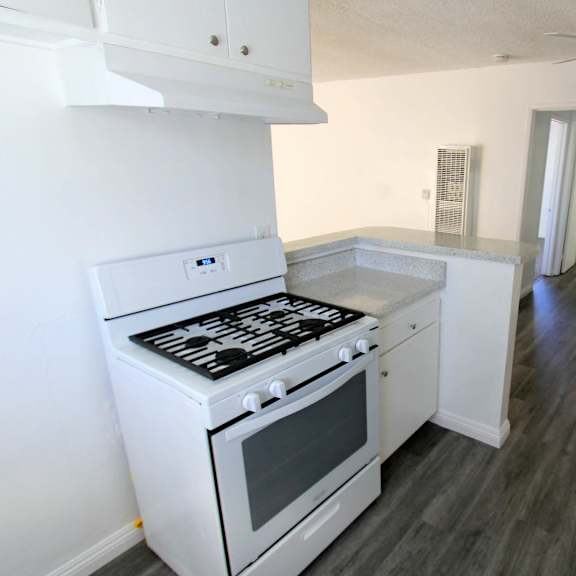 A white stove and oven in a kitchen with wood flooring.