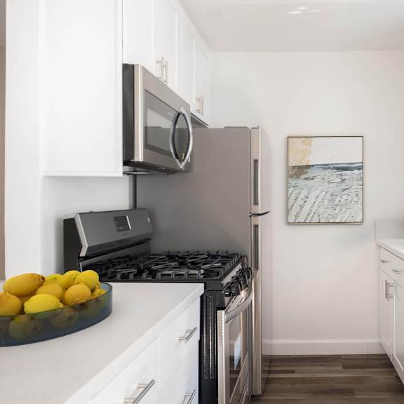 A kitchen with white cabinets and a black stove top.