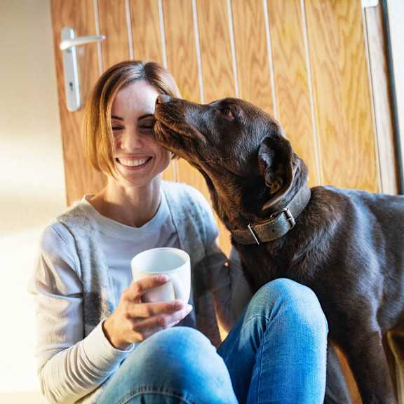 a woman is sitting on the floor with her dog